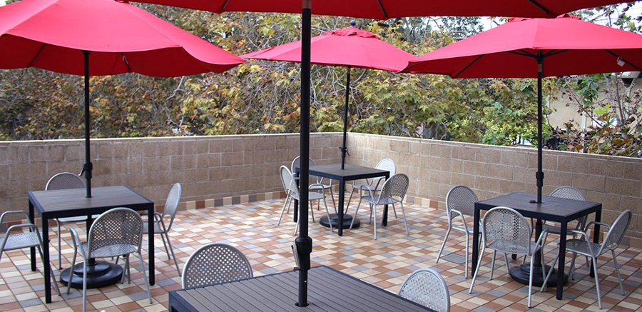 2 of 4, Women's Center outdoor spacious balcony area with tables, chairs, umbrellas - UC San Diego