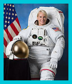 Photo portrait of Kate Rubins wearing NASA spacesuit, holding her helmet